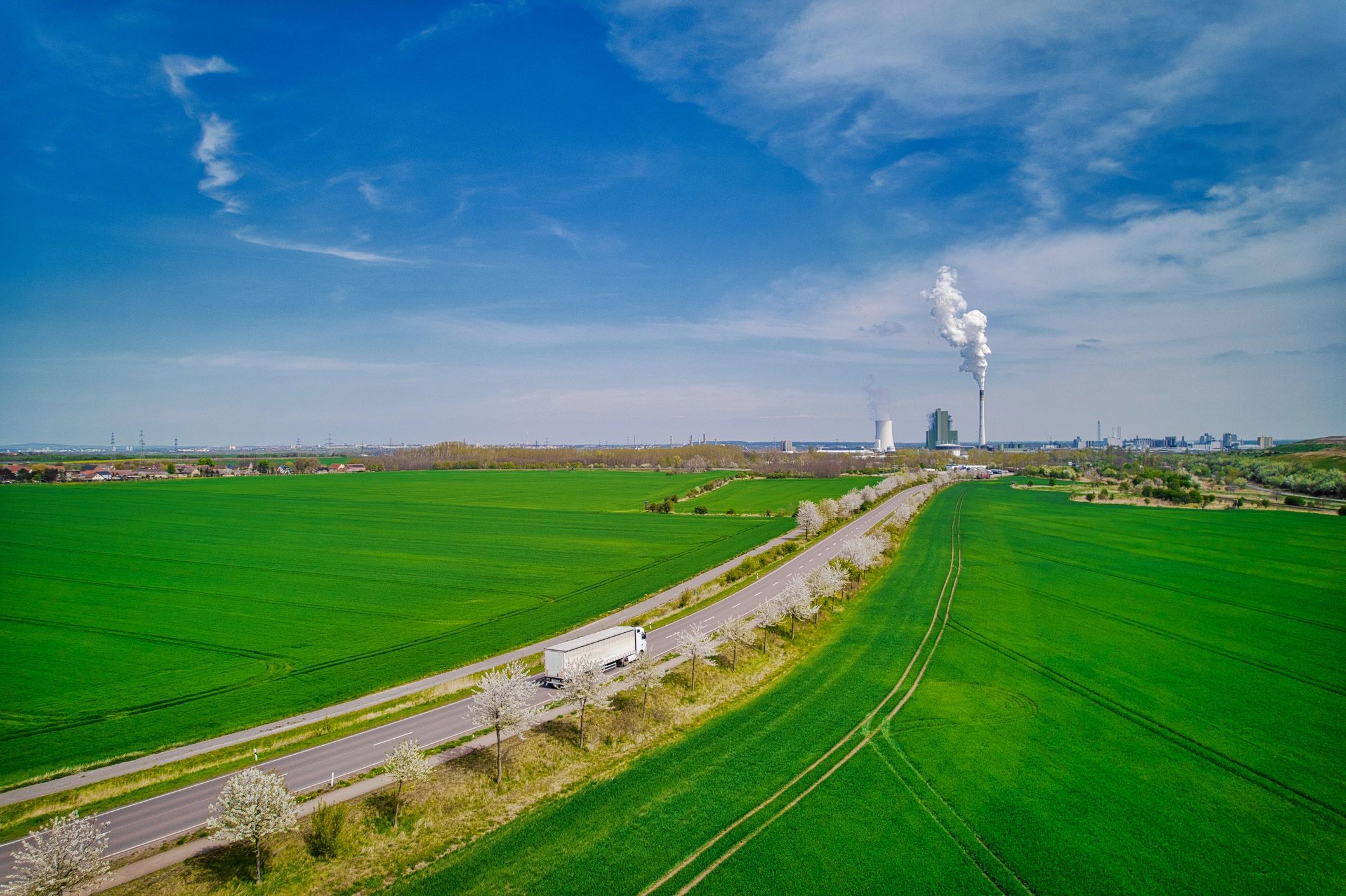 White delivery truck on the road near industrial facility
