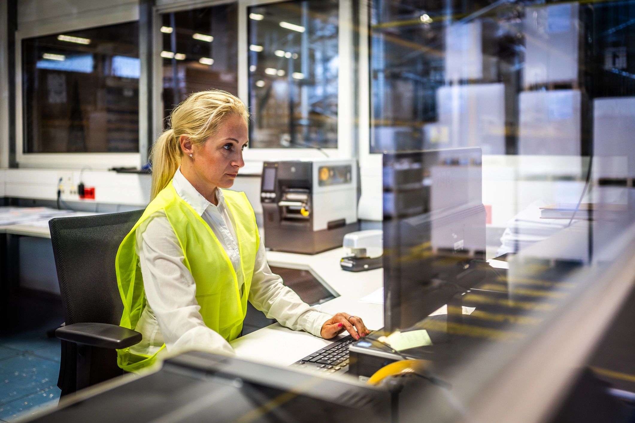 Shipping operator working at a computer in a warehouse office