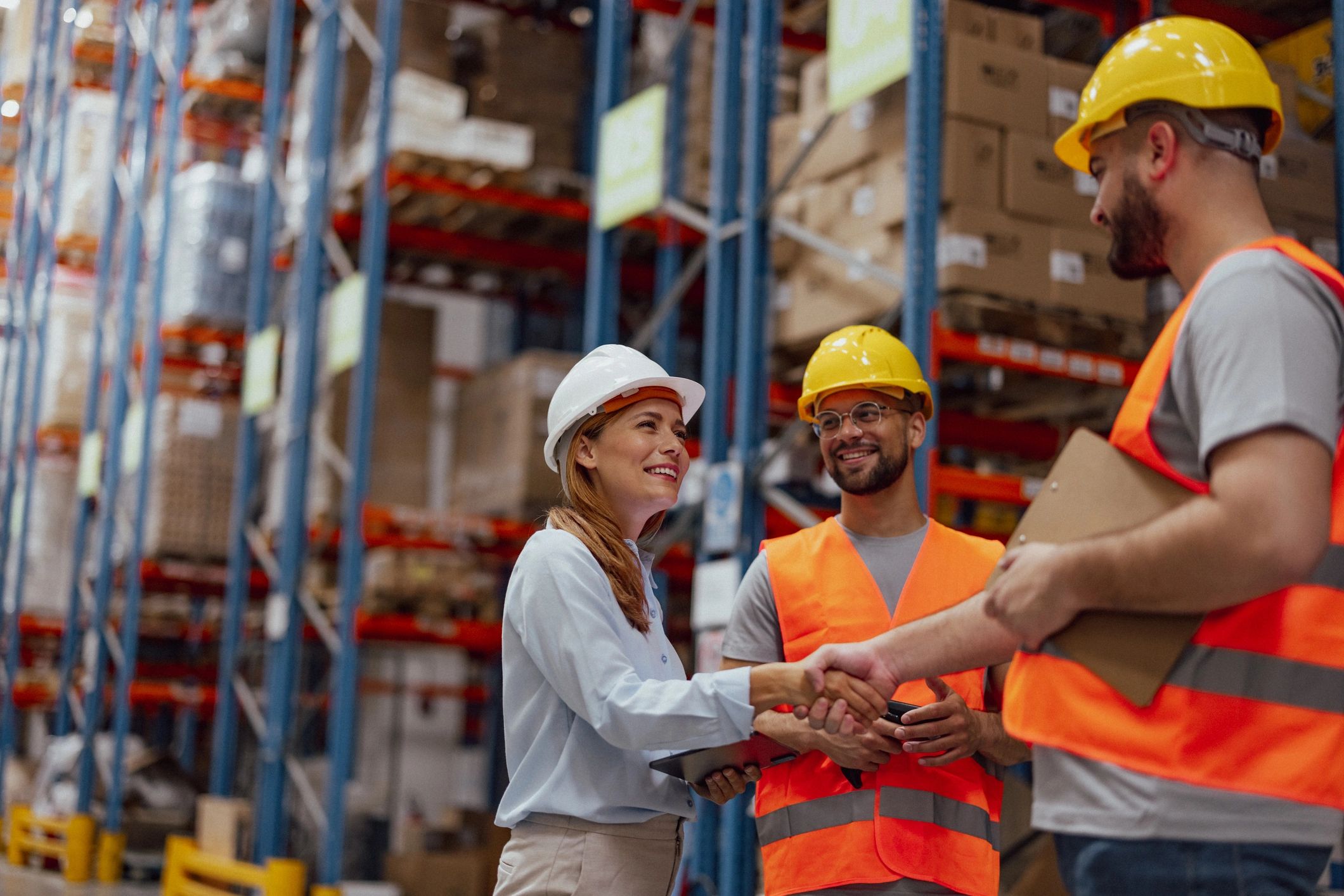 Manager and warehouse worker shaking hands in a warehouse