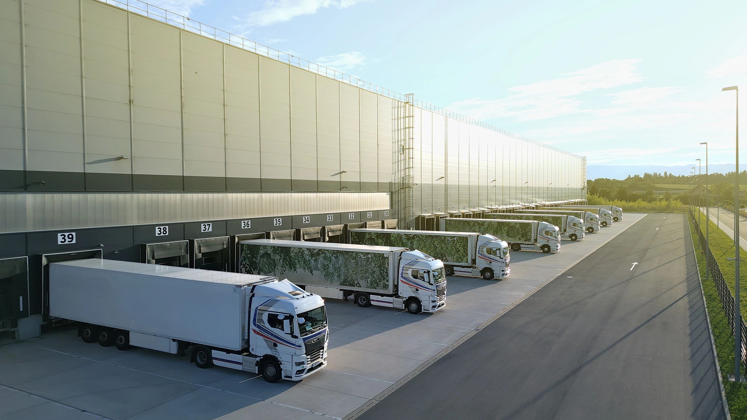 Trucks lined up at a modern distribution warehouse loading bays
